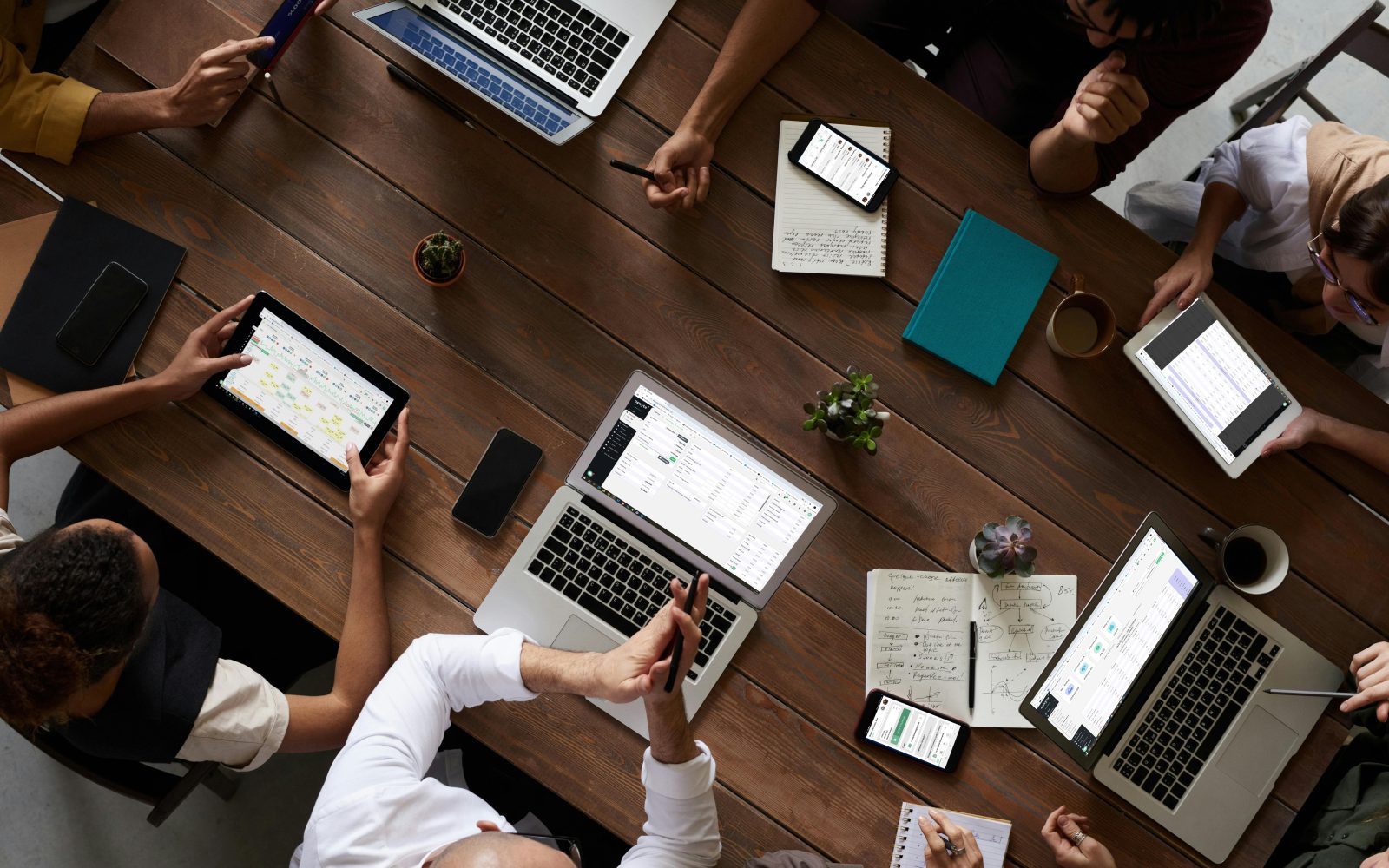 An operations team around a table with laptops and tablets